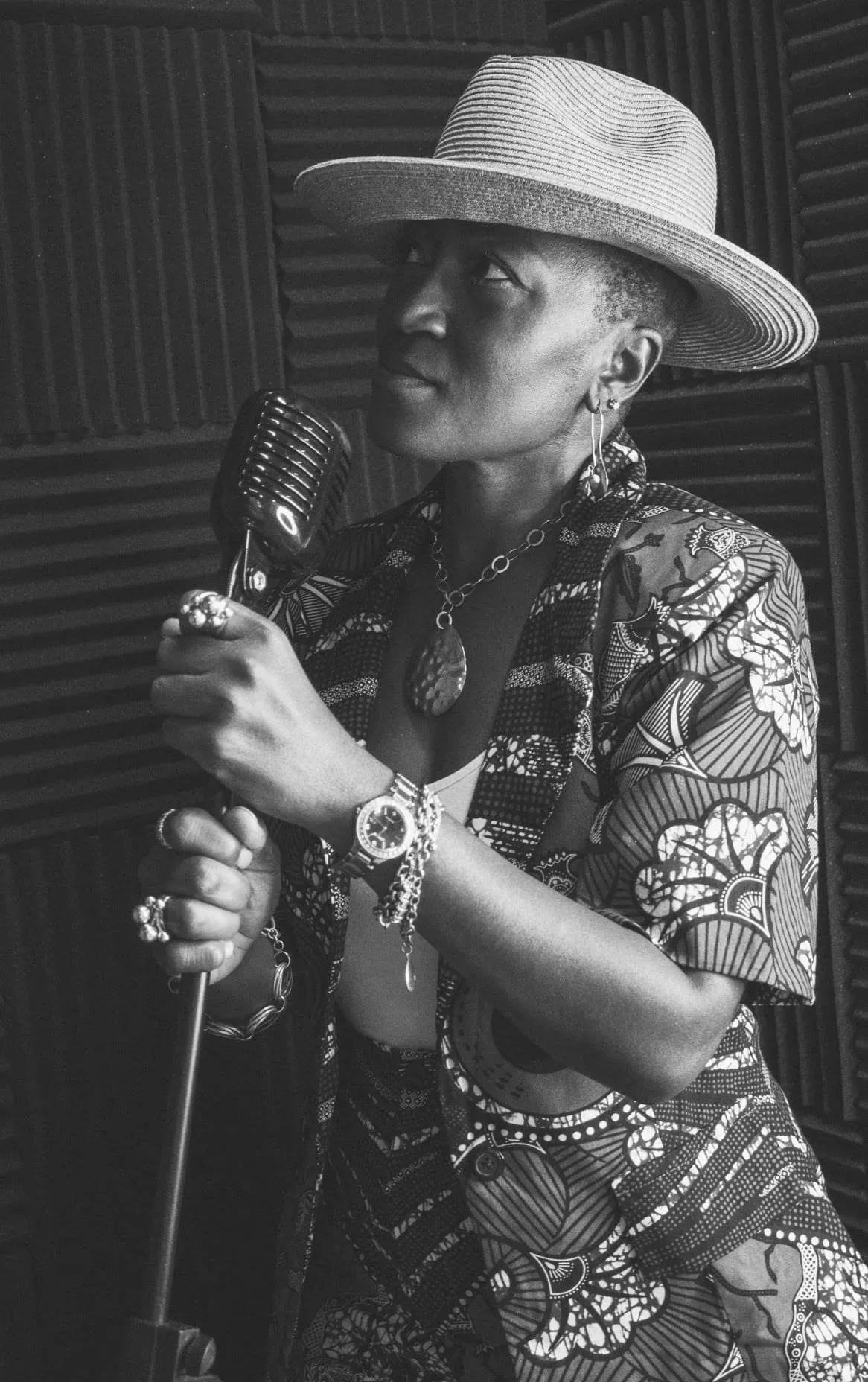 Lady Charise holding a vintage microphone in a recording studio